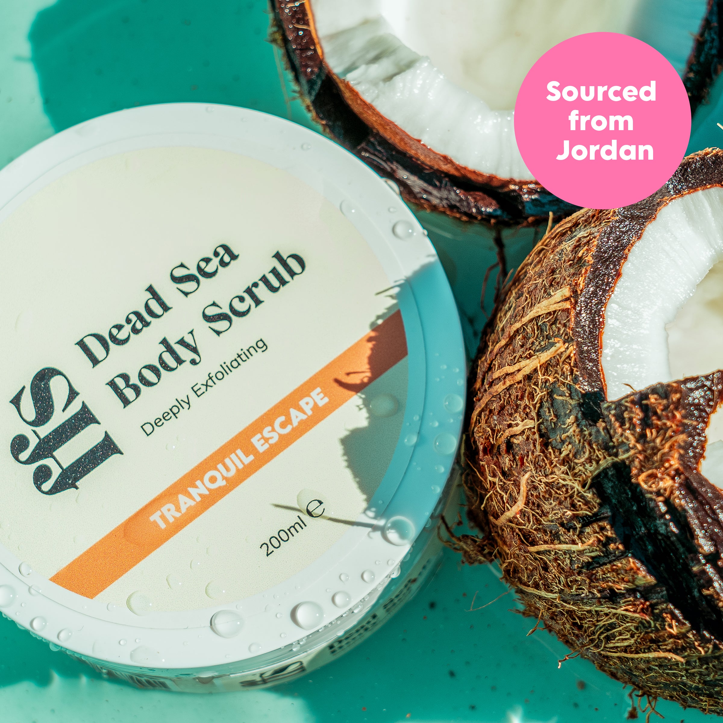 FFS Tranquil Escape Dead Sea Body Scrub jar beside halved coconuts on a teal background